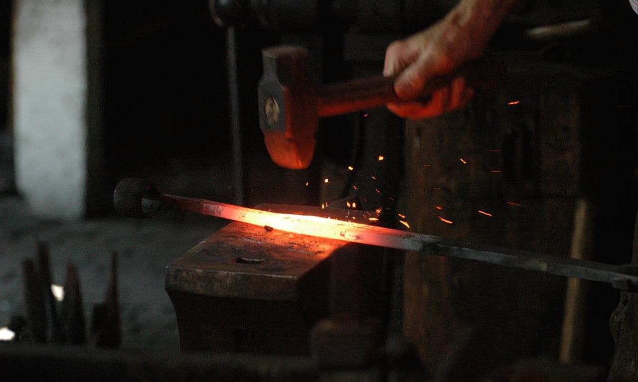 1280px-Blacksmith_working
