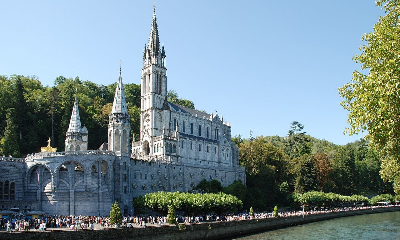 1280px-Lourdes_Basilique_et_gave-e1549219628621